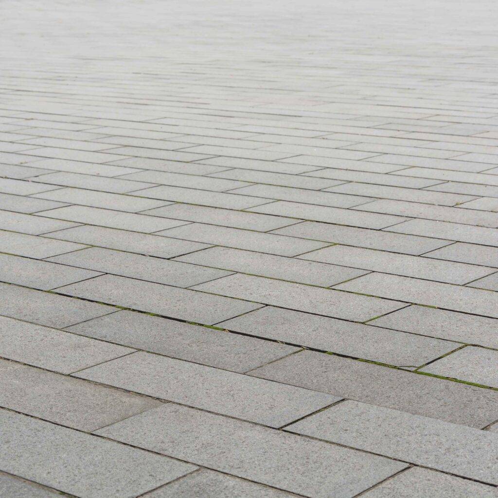Grey brick stone street road. Light sidewalk, pavement texture